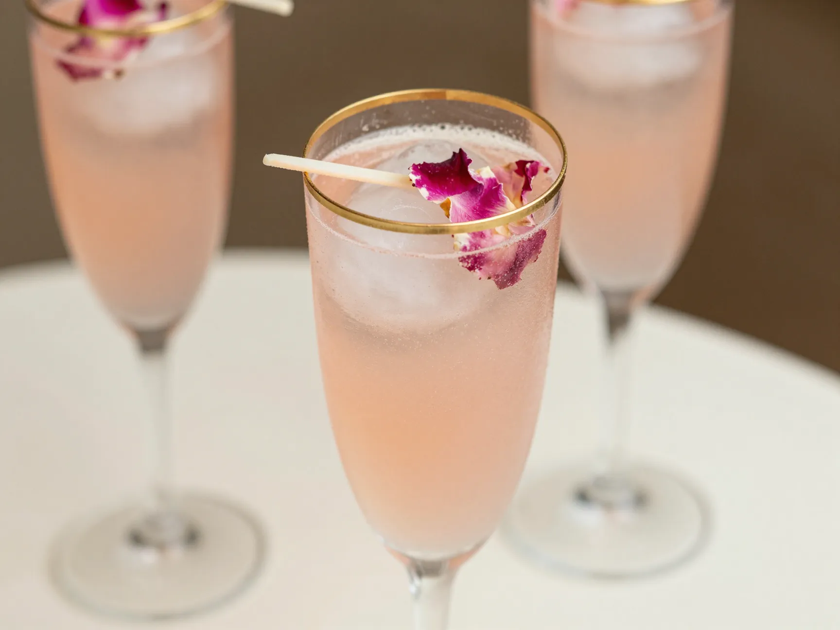 Elegant bridal blush mocktail gold rim flute rose petal ice