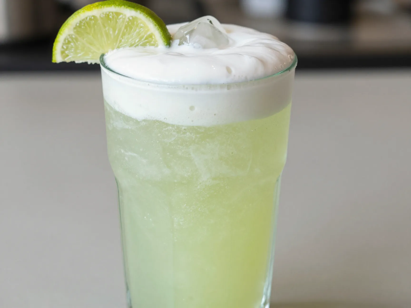 Lime slush dirty soda with coconut cream and lime wheel garnish