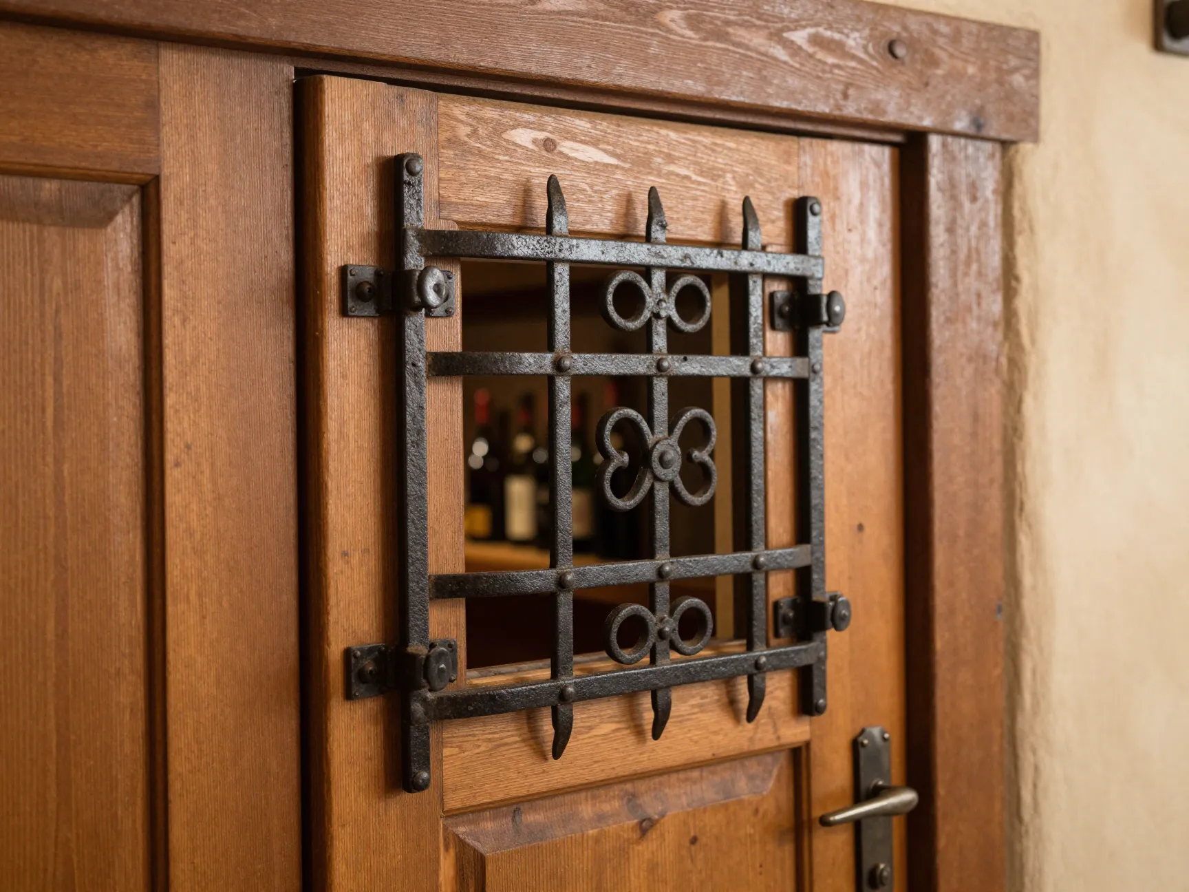 Tuscan speakeasy cellar door with a small hinged iron grille panel