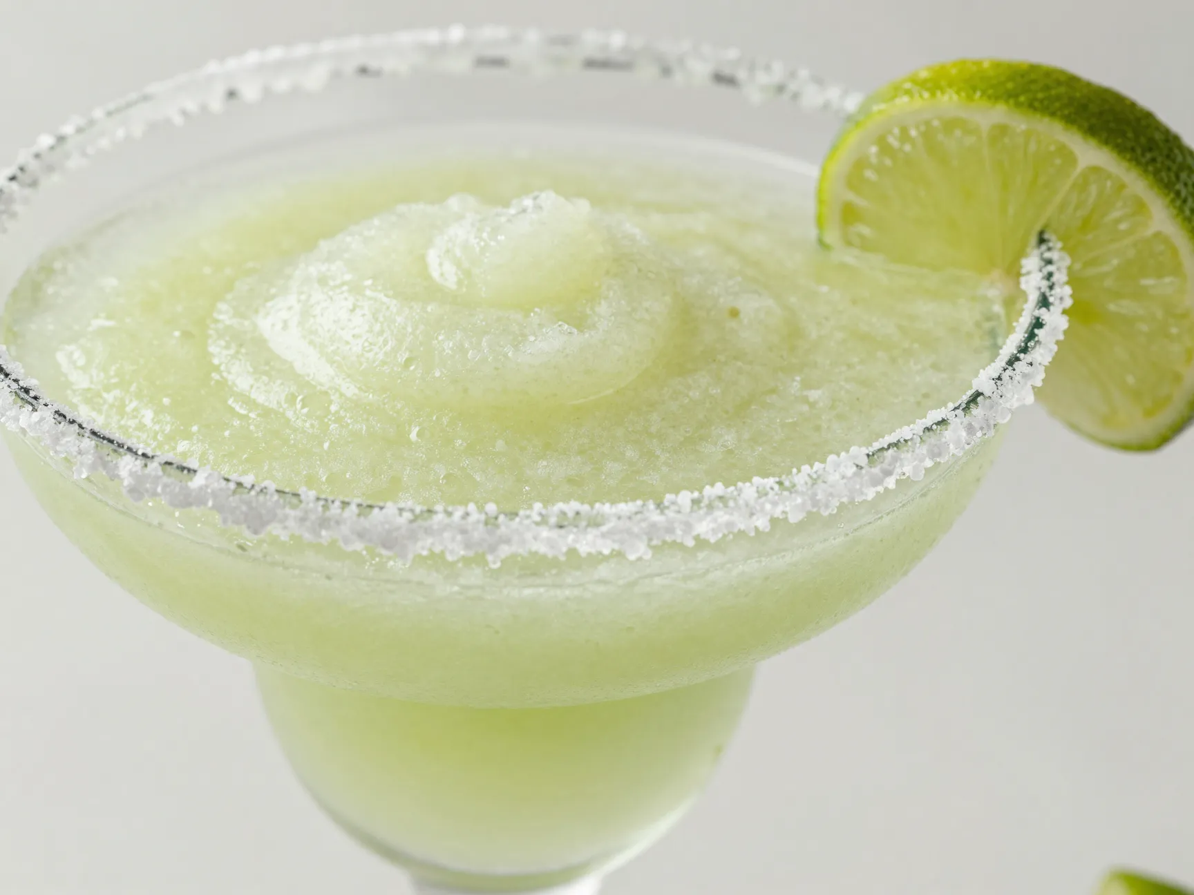 Salt rimmed lime margarita slush with a lime wheel garnish