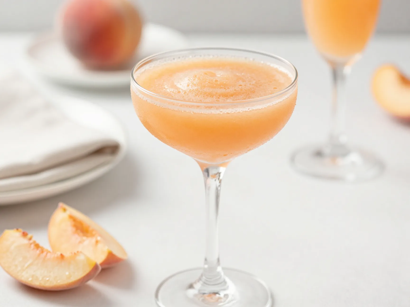 Peach bellini slush served in a chilled champagne flute