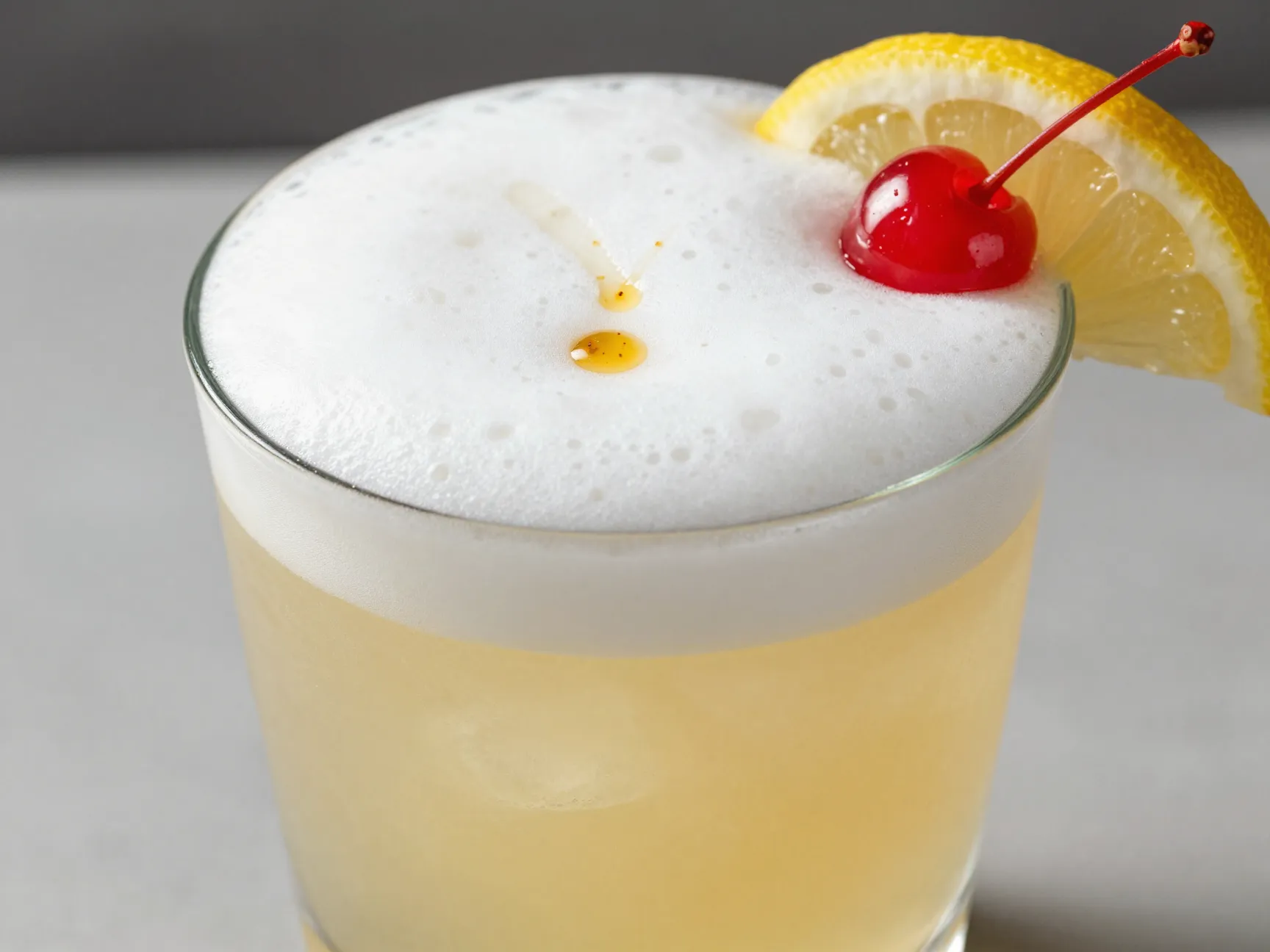 A shaken whiskey sour with a frothy egg white top
