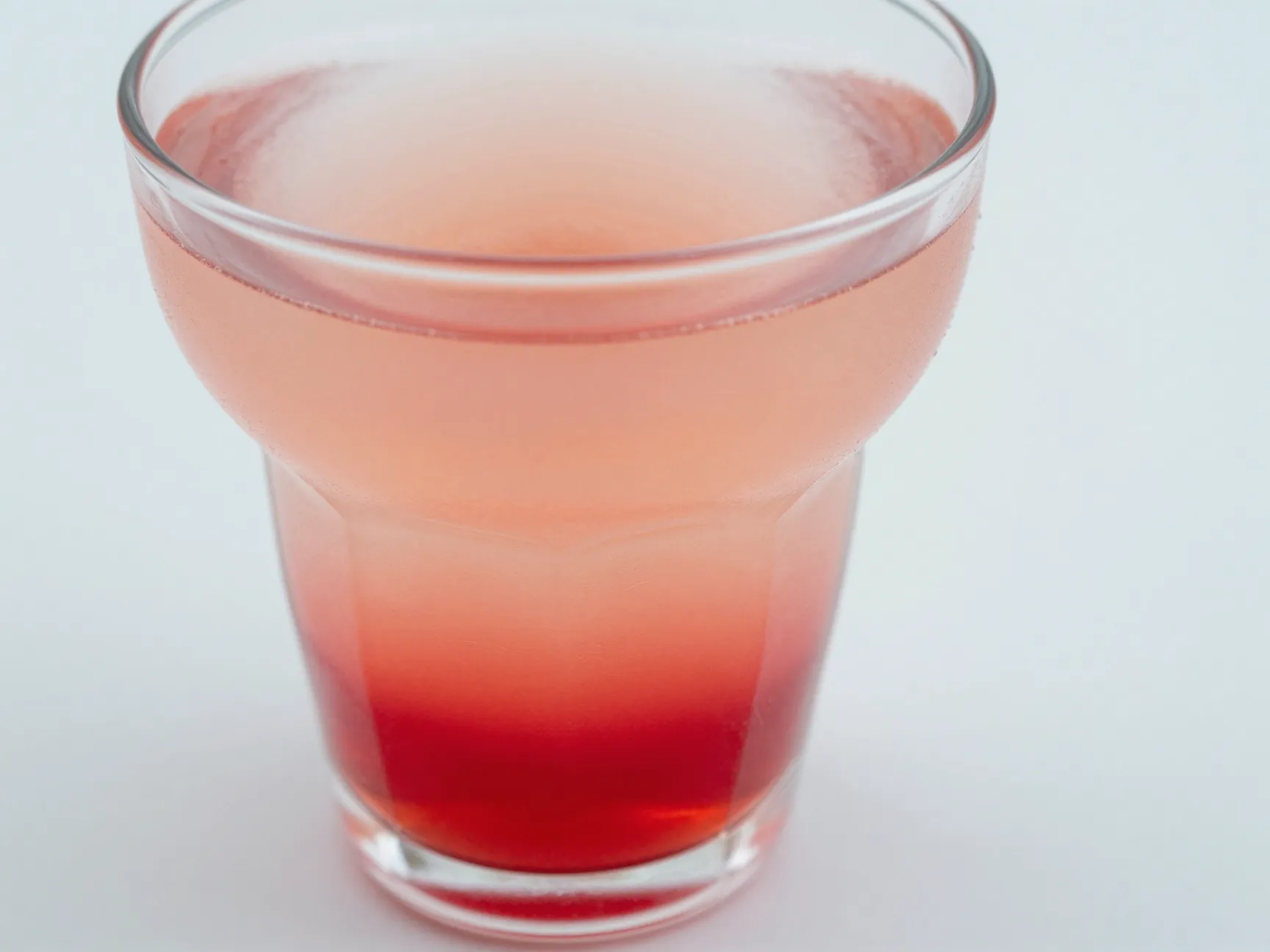 Masterful drink with vivid sunset color gradient in glass