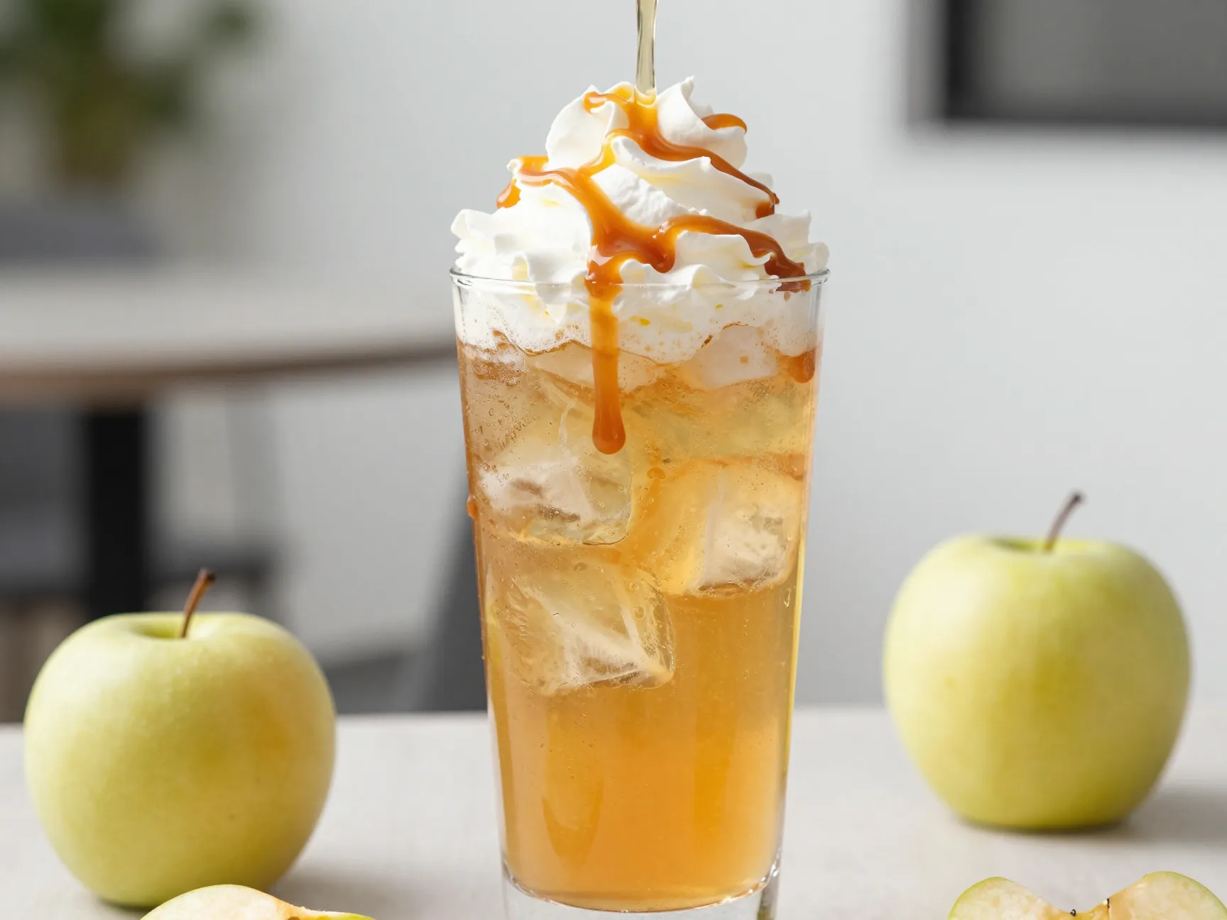 Iced caramel apple cider in a tall glass with ice