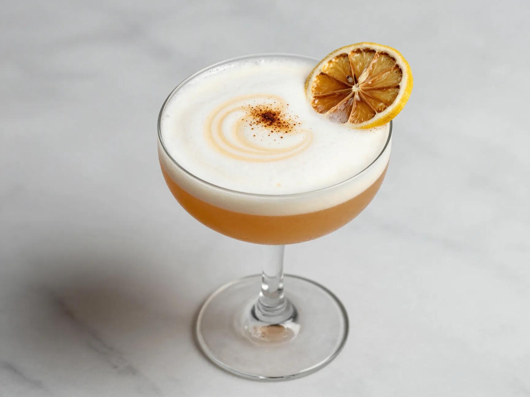 Maple whiskey sour with frothy egg white and lemon wheel
