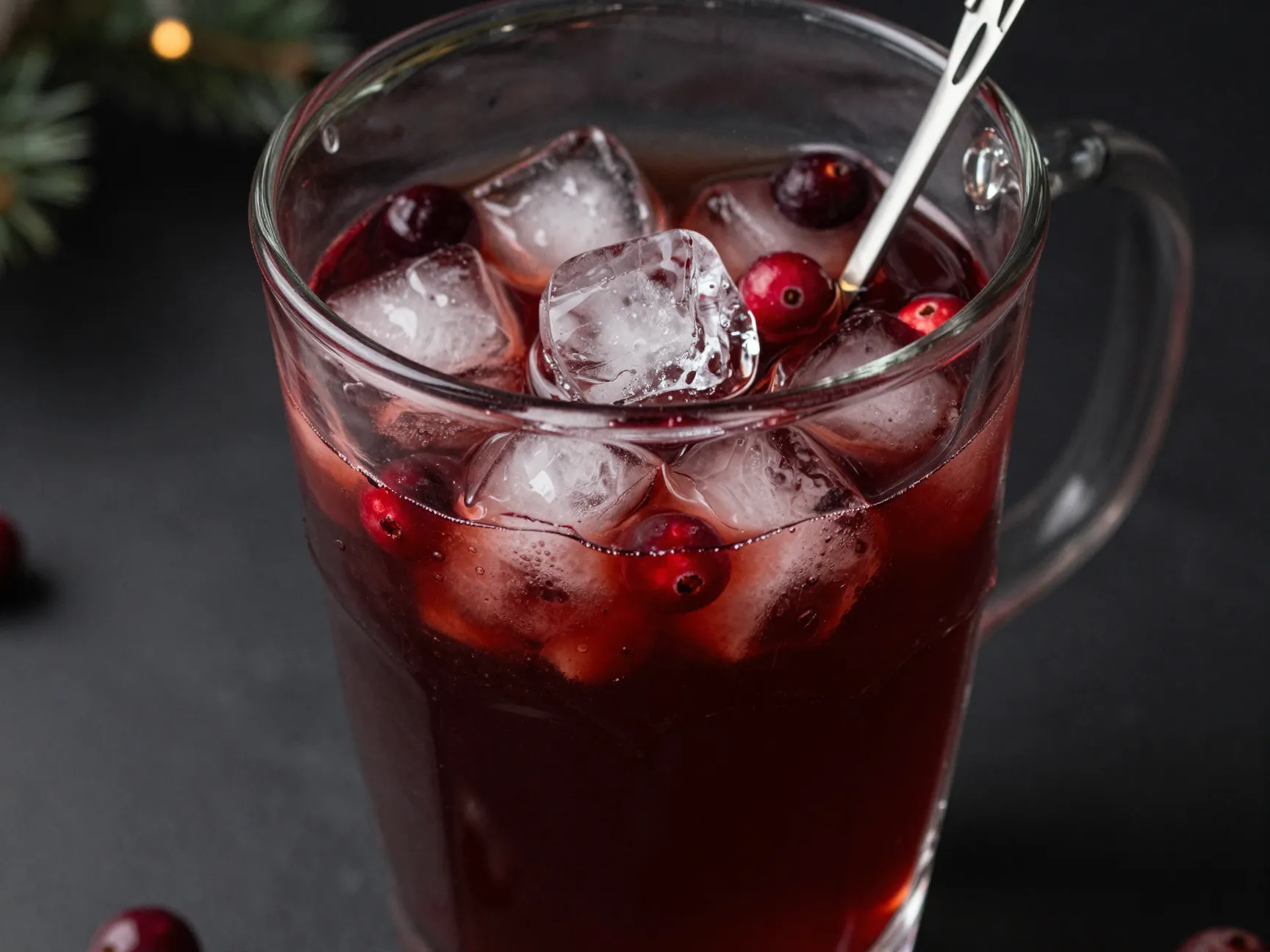 Dark rum and cranberry juice punch with ice in pitcher