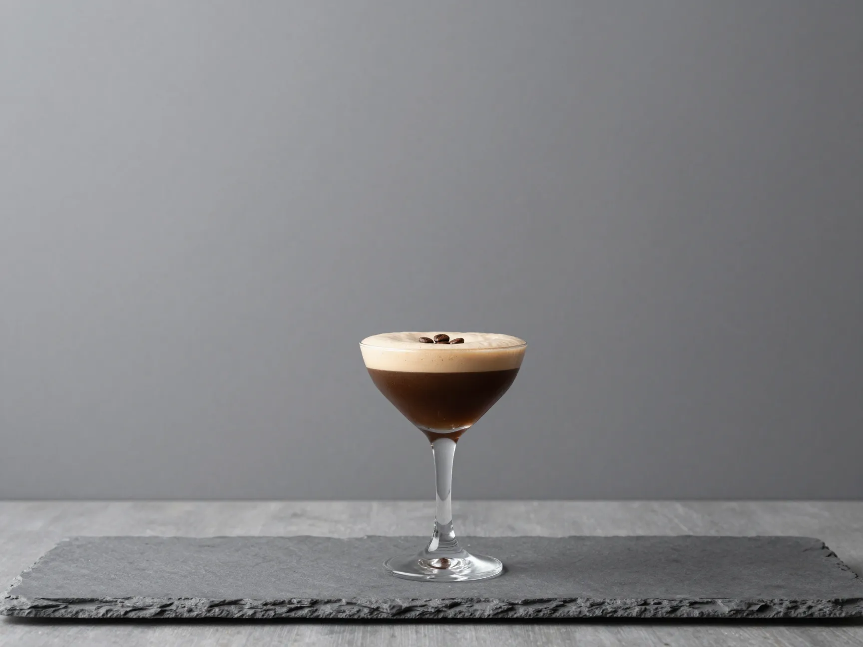 Lone espresso martini cocktail on gray wooden plank negative space background