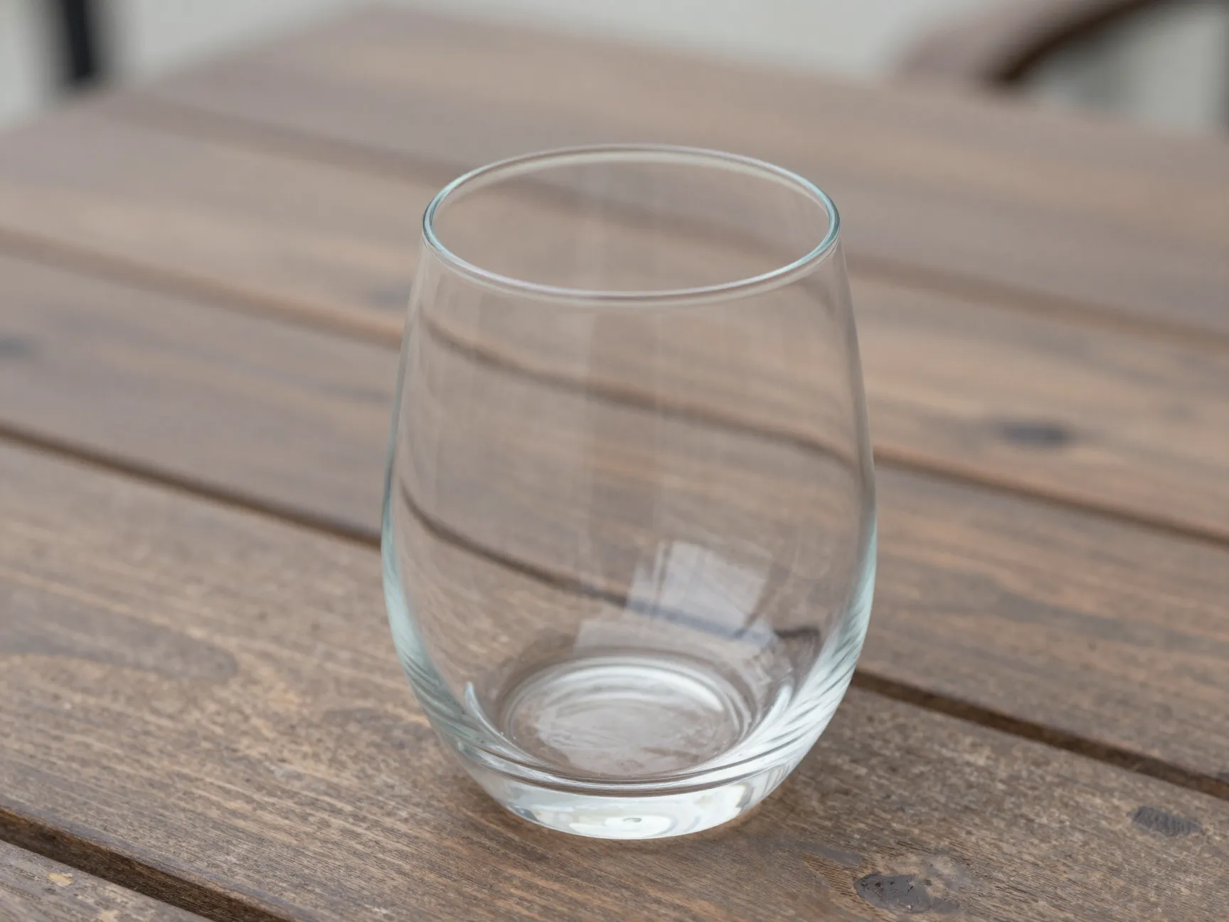 Clear compact modern outdoor friendly stemless wine glass on rustic table
