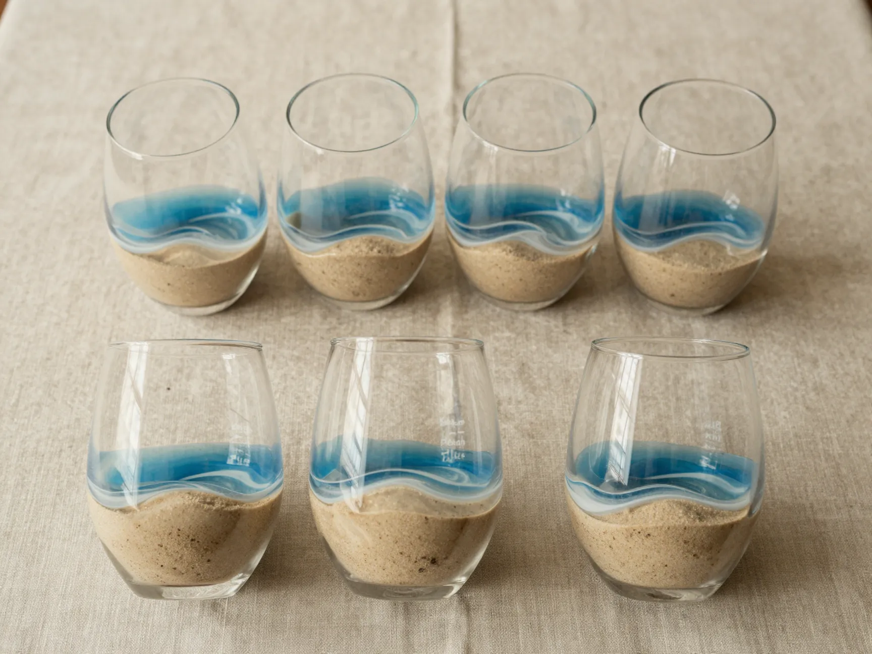Expressive sandy beach blue ocean wave resin stemless wine glass duo