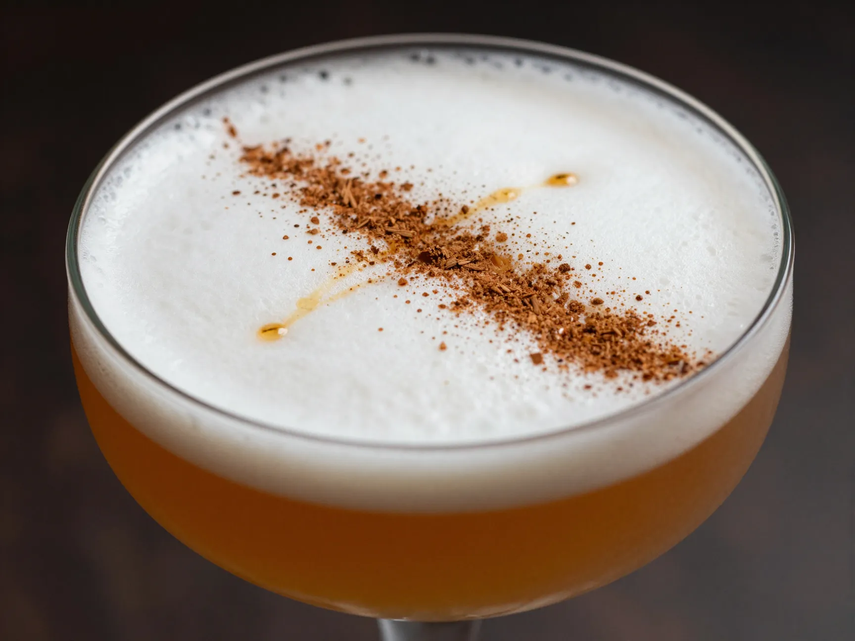 Chai whiskey sour with foam and cinnamon dusting